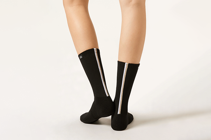 A pair of feet in black trekking socks from Calzedonia with COOLMAX® fiber for moisture-wicking